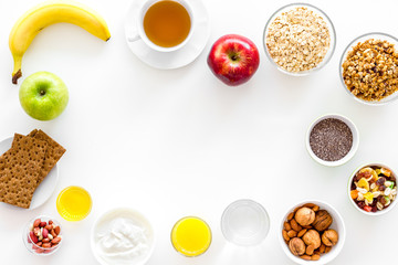 Ingredients for healthy breakfast. Fruits, oatmeal, yogurt, nuts, crispbreads, chia on white background top view copy space