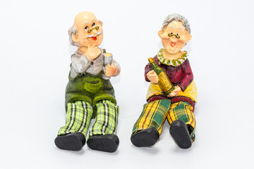 Pottery figurines of old couple drinking wine