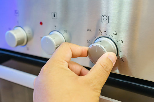 Close up male hand while using the microwave in his kitchen