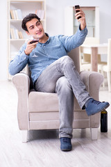 Young man drinking wine at home