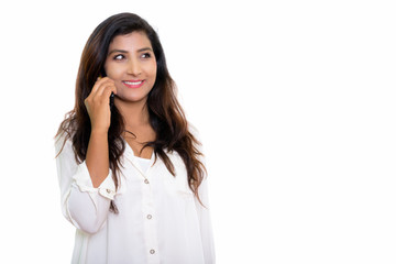 Thoughtful young happy Persian woman smiling while talking on mo