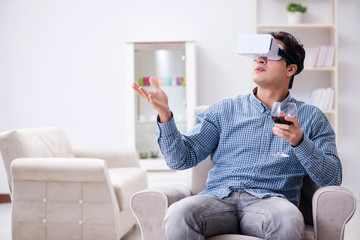 Young man drinking wine at home