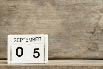 White block calendar present date 5 and month September on wood background