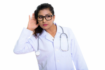 Studio shot of young beautiful Persian woman doctor listening an