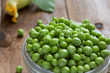 a bowl of young green ripe peas on a table close