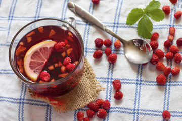 in a mug red berry tea made from wild strawberry on a table