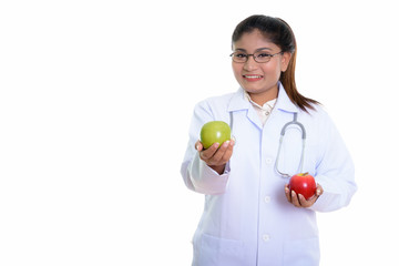 Studio shot of young happy fat Persian woman doctor smiling whil