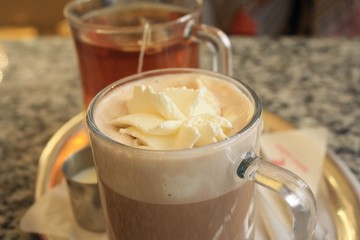 Hot chocolate with whipped cream in a transparent glass mug