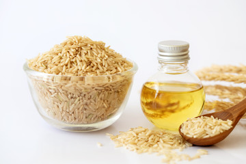 Close up brown rice seed and rice bran oil in bottle  and unmilled rice on white background , good...