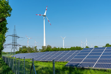 Solar panels, wind engines and an electricity pylon seen in Germany