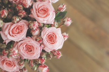 Pink Beautiful Roses Bouquet over Wooden Table. Top view Copy Space. Vintage Greeting Card