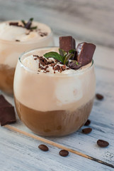 Iced Mocha Coffee with Whip Cream, Summer Drinking times. Coffee Beans. rustic textured Wooden Background. Mint Leaves