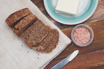 Whole Grain Bread with Seeds. Breakfast. fitness Diet Bread Sliced with Butter. Wooden board.