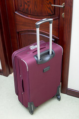 Travel suitcase with pull-out handle at the front door