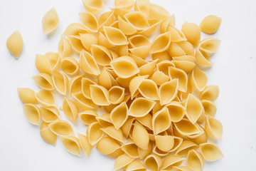 Pile of uncooked macaroni on white background