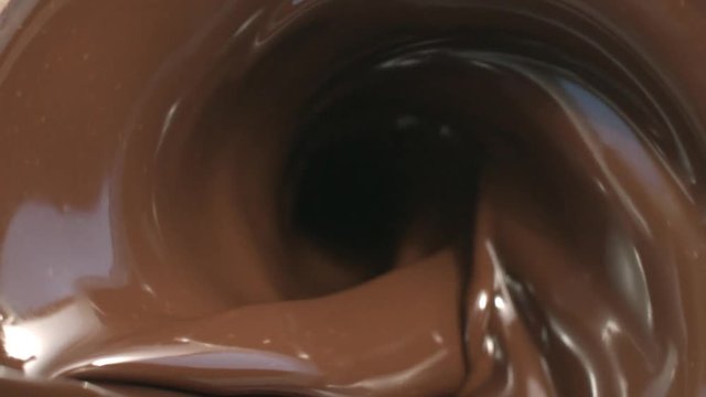 Splashes of Chocolate Whirlpool Pouring macro tabletop in slow motion splashes and swirl