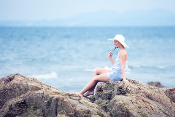 holliday,relax,nature.Beautiful young girl woman sits on the beach, dreaming and looking at the sea.