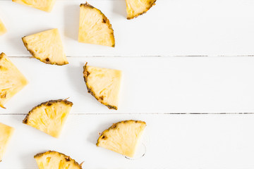 Naklejka premium Pineapples on white wooden background. Summer concept. Flat lay, top view