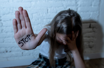 Pretty young girl showing the word stop written on her hand. Violence,abuse and bullying concept