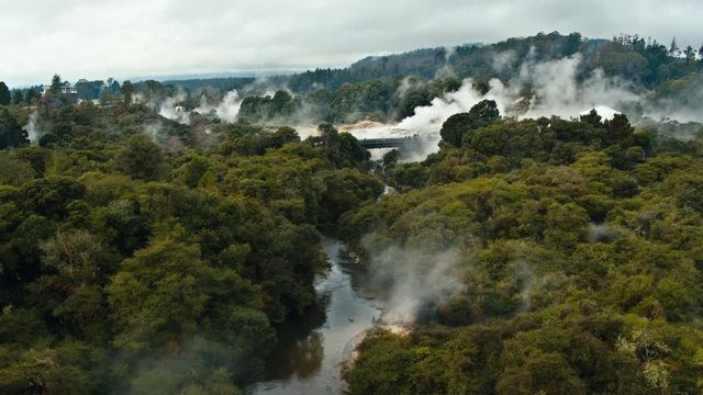 Drone shot geysers steaming in forest Rotorua in New Zealand