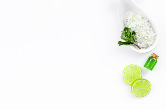 Natural Organic Cosmetics With Lemon Or Lime. Citrus Slices, Aromatic Spa Salt, Mint For Deoration, Bottle With Oil On White Background Top View Copy Space