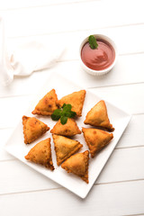 homemade mini samosa served with red sauce, selective focus