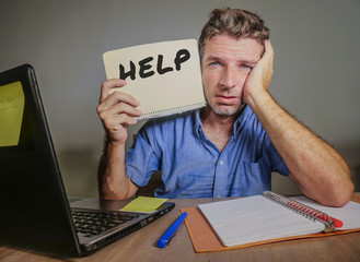 young desperate and stressed businessman feeling overwhelmed working with laptop computer at office...