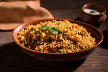 Indian Vegetable Pulav or Biryani made using Basmati Rice, served in terracotta bowl. selective focus