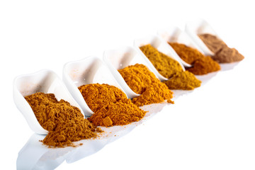 Small  ceramic bowls of Indian spices isolated on white  background.