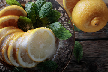 Lemon slices with sugar and mint leaves.