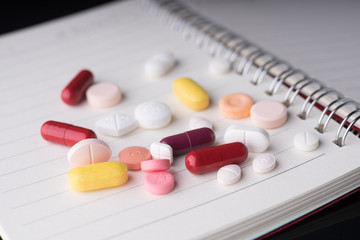 Medical pills and supplement capsule with a notebook.Medical health concept..