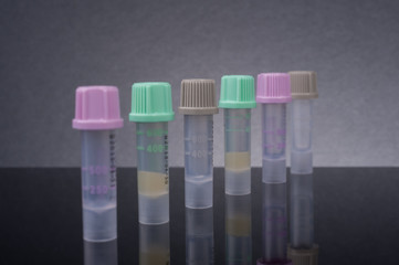 Blood sample tube on black glass table with reflection.Selective focus shot.