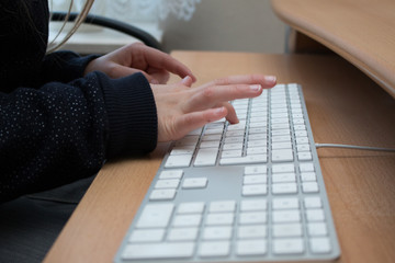 Die Hände eines Kindes benutzen eine Tastatur