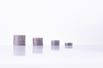 Stacks of coins isolated over white background with reflection.
