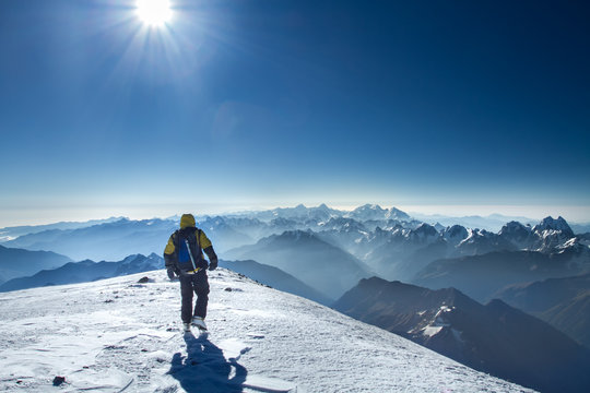 A man stands on top of Mount Elbrus