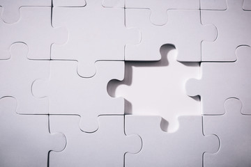 Empty and blank missing piece of jigsaw in white color background - business strategy and thinking solving problem concept.