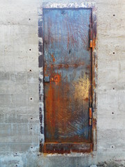 unpainted metal door of a concrete bunker