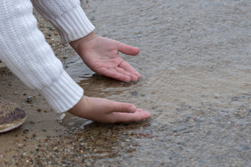 Childs hands feeling the water