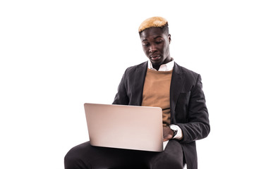 Portrait of confident afro business man dressed in classic elegant suit using laptop for work isolated on gray background