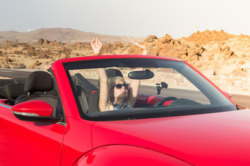 The girl driving a car. Portrait of Young girl driving cabriolet at sunset.