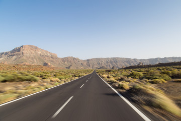 Road to El Teide volcano peak. Travel by car. Volcanic fields on the volcano. Landscape with road in Teide National Park, Tenerife, Canary Island, Spain