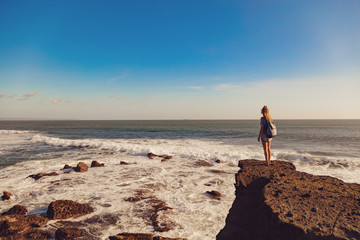 Girl enjoying the tropical sunset on the ocean shore.