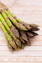Bunch of fresh asparagus on wooden table.