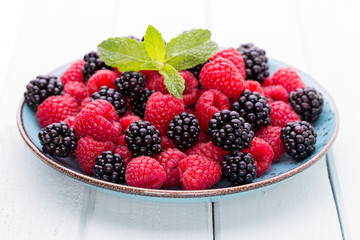 Fresh raspberries in a plate on a  vintage background.