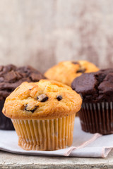 Homemade muffins with chocolate, vintage background.