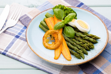 Fried asparagus with broccoli and lemon and carrot.