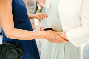 Obraz premium Old ladies hold each other hands while greeting
