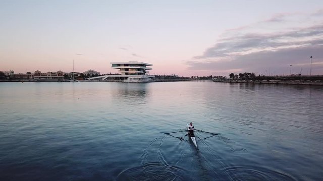 Spain, Valencia aerial shooting, bird-eye view of port, man is rowing in a special sports boat skiff. nice view of a bay and sailboats, cool yachts, nice view of the sea