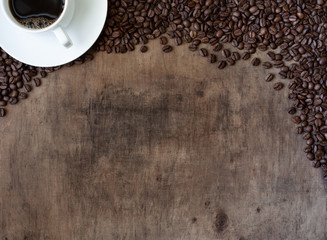 Wooden background with coffee cup and coffee beans