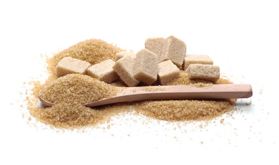 Brown cane sugar pile and cube in wooden spoon isolated on white background, sugarcane texture